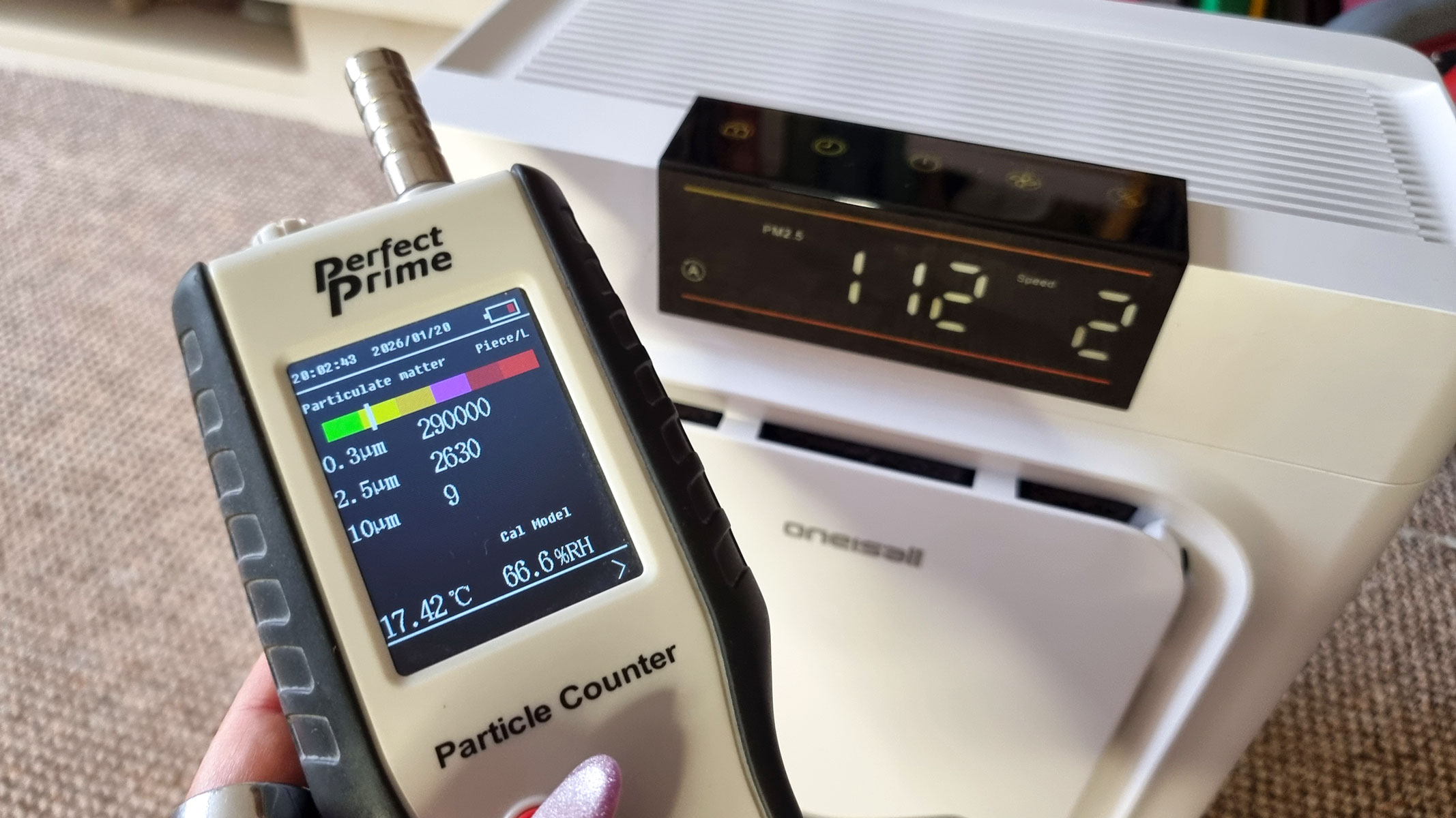 A picture of our reviewer testing the Oneisall Pet Air Purifier using the Perfect Prime Air Particle monitor