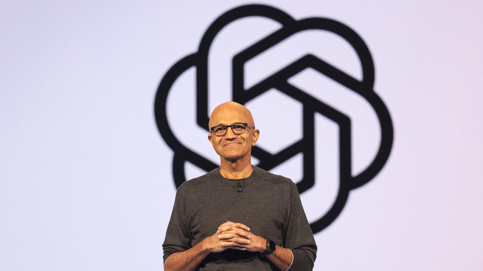 Microsoft Chairman and CEO Satya Nadella speaks in front of the OpenAI logo at the Microsoft Build 2025, conference in Seattle, Washington on May 19, 2025.