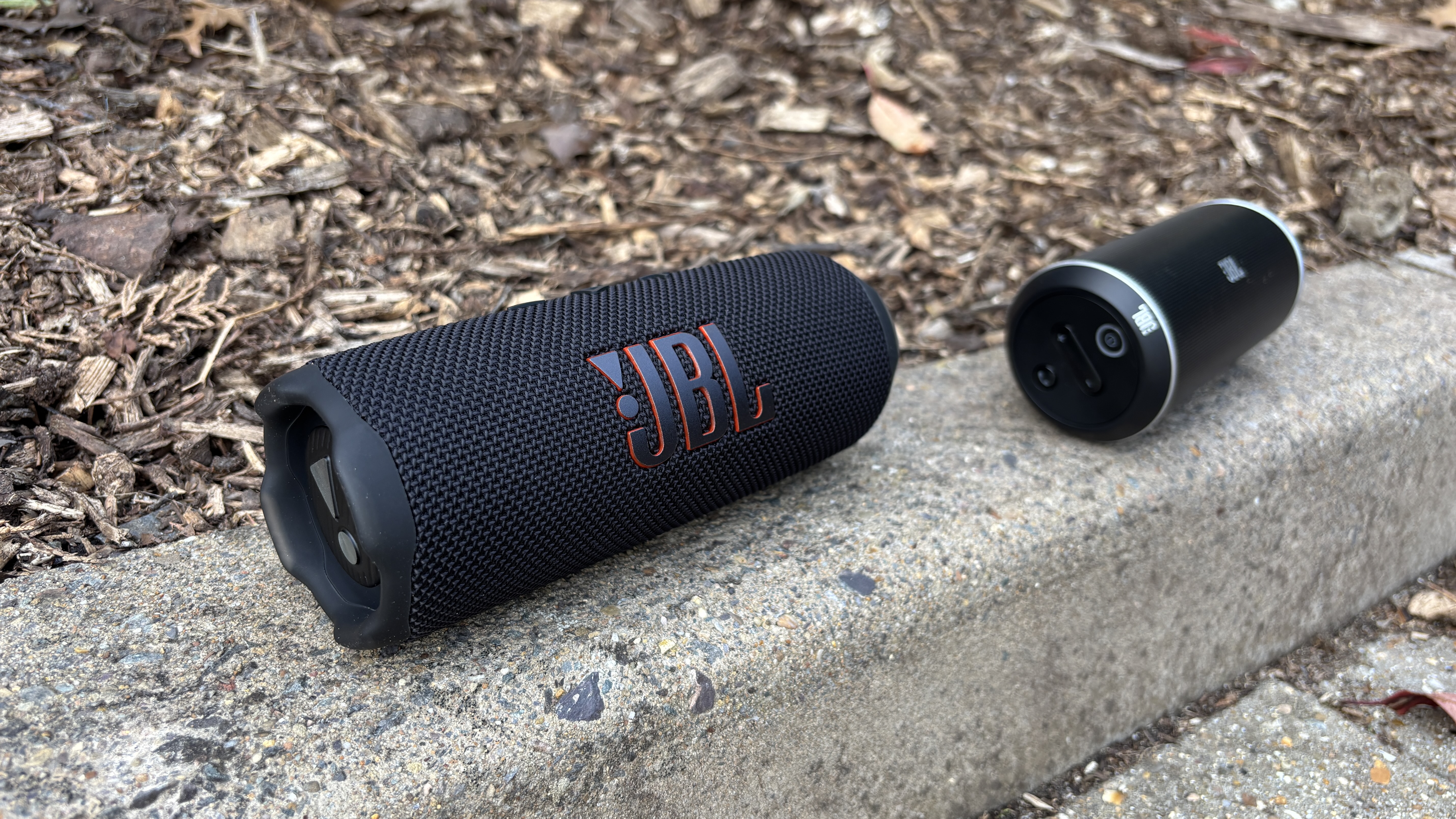 JBL Flip 7 next to JBL Flip on a kerb