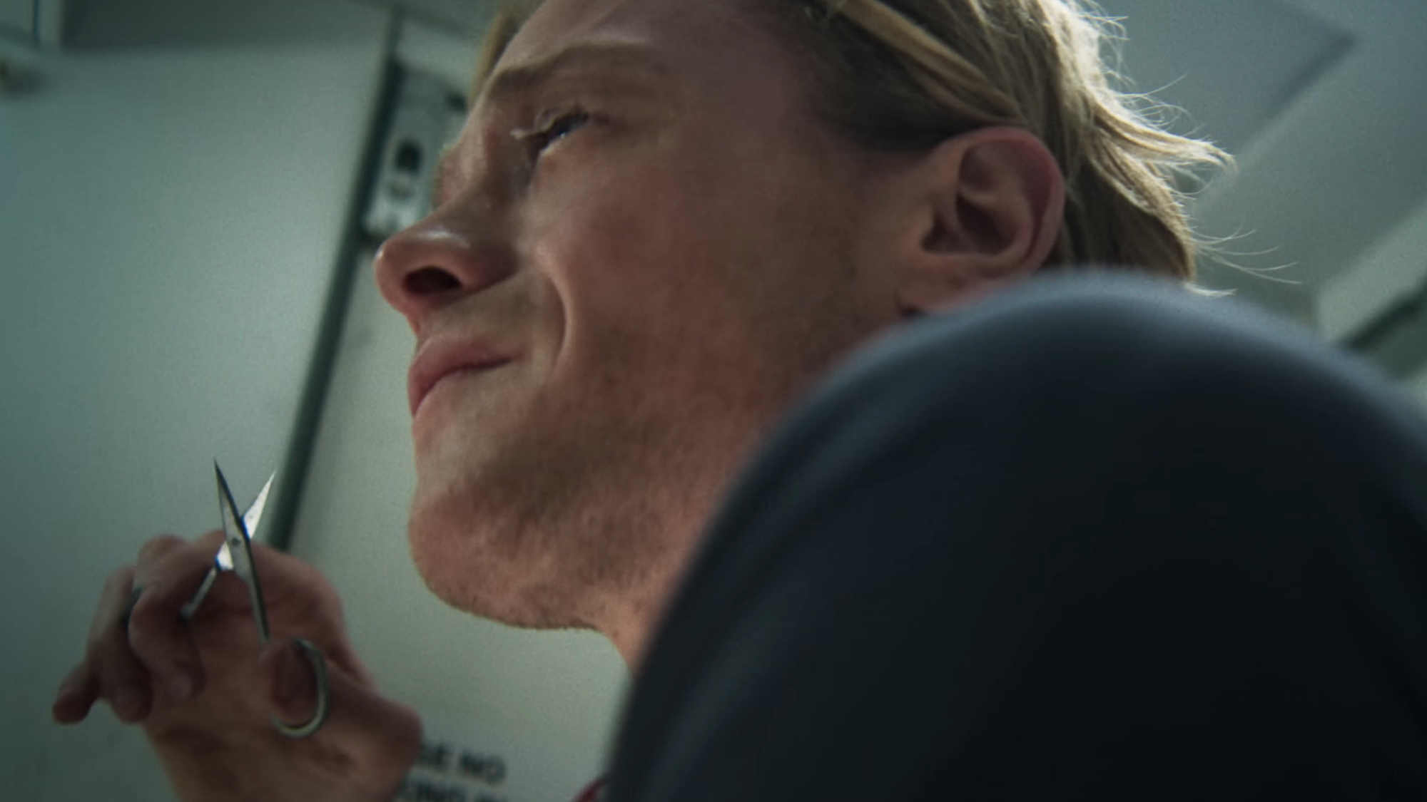 Matt holding small scissors and starting to cut the skin across his eyes in Clayface