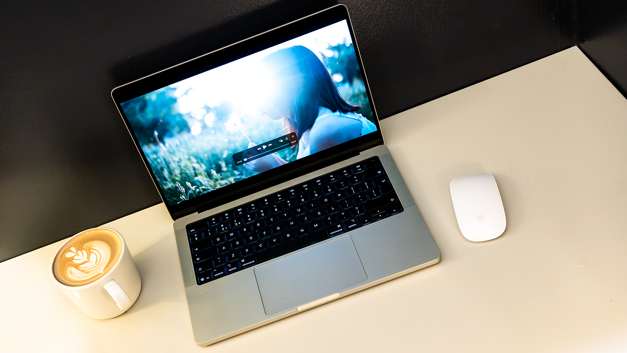 Apple MacBook Pro 14 (M5 Max) on a white table in front of a black wall