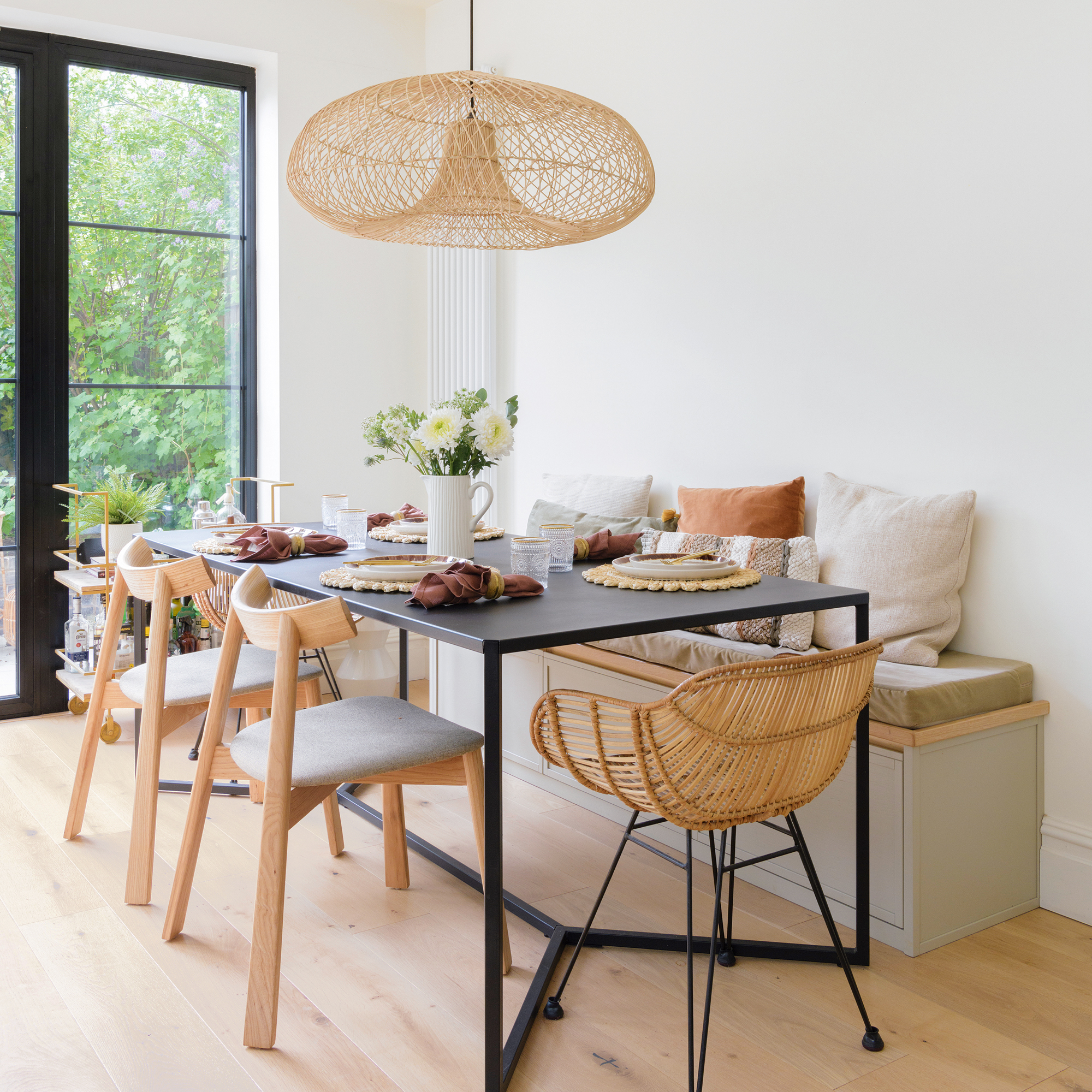 a dining area in an open plan kitchen with banquette seating beside a patio door