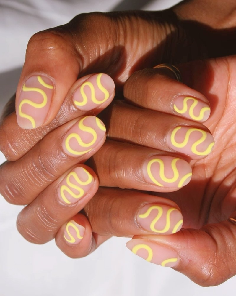 A yellow pastel swirl nail design