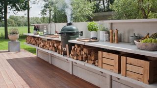 outdoor kitchen set up with wooden floor and steel top surfaces by garden house design