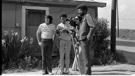 Filmmakers stood around a camera mounted on a tripod. 