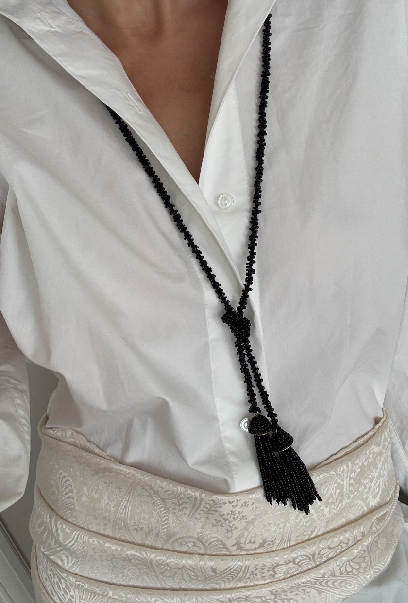 An image of @nazleeshkri wearing a tassel necklace, one of the biggest It girl trends for winter 2026.