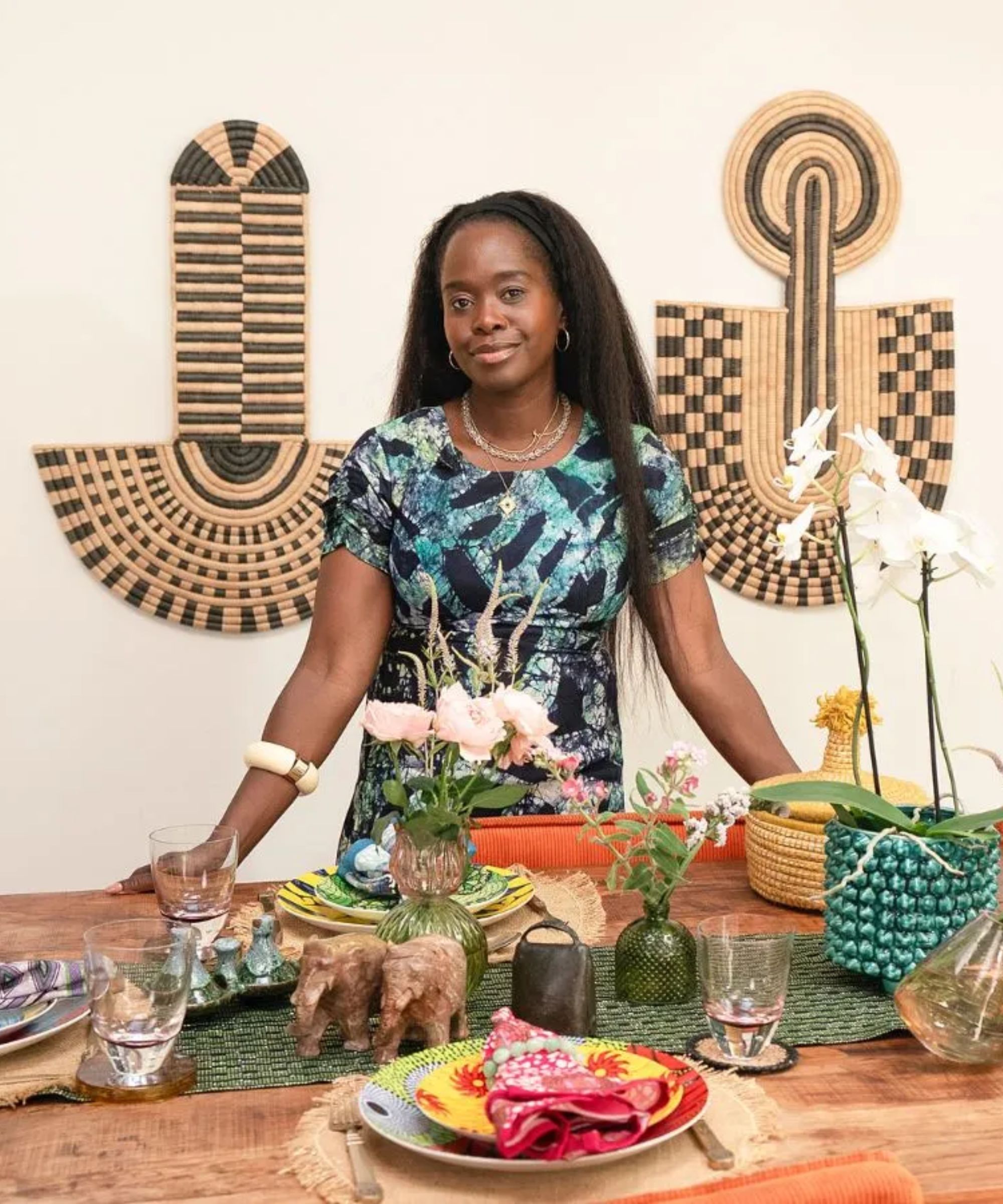 Eva Sonaike in her home by a table set up for a dinner party 