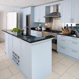 blue cabinet kitchen with white tiled flooring