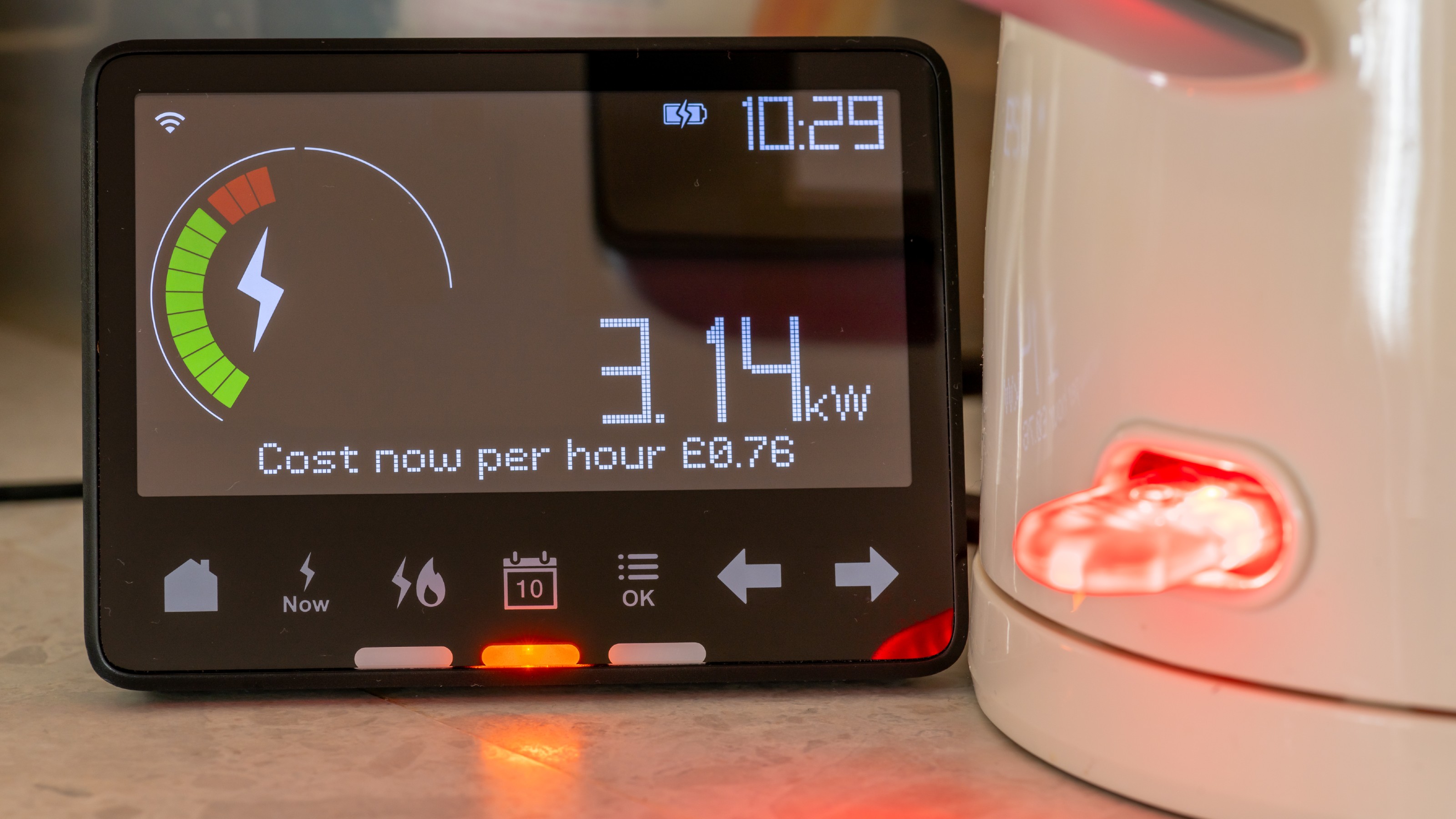 Smart meter on a work top next to a kettle with a red light switch