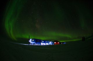 The Halley VI Research Station at night, with the Southern Lights visible in the sky.