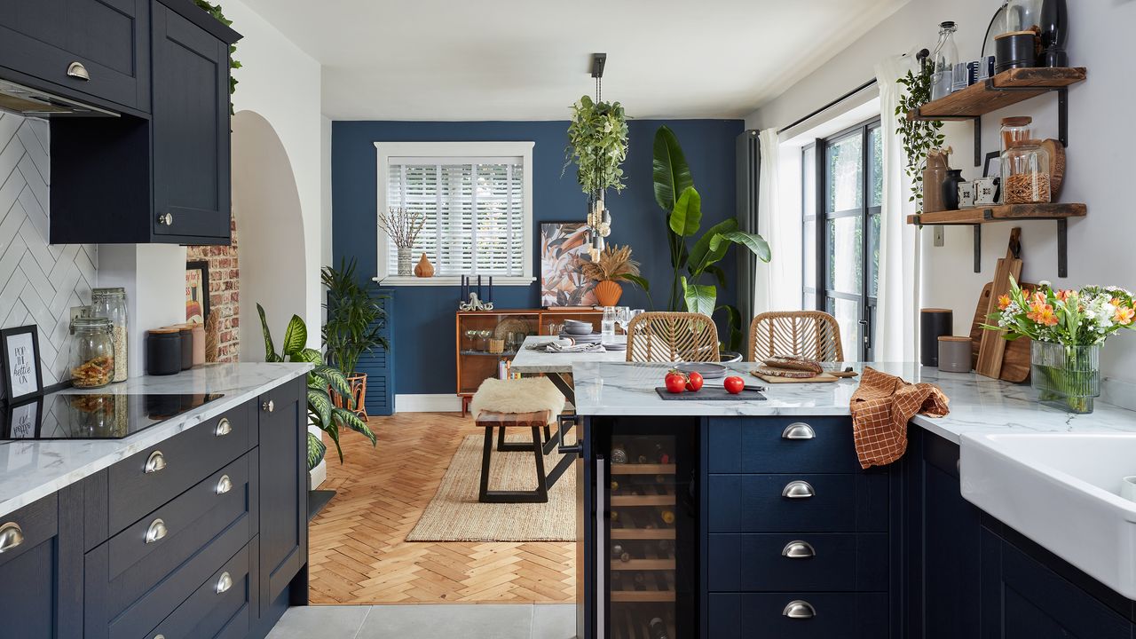 Navy kitchen with herringbone flooring in dining area