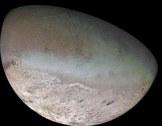 The surface of Neptune's moon Triton, as seen by Voyager 2. The greenish areas are called "cantaloupe terrain" while the pinkish regions is methane ice in the south polar cap.