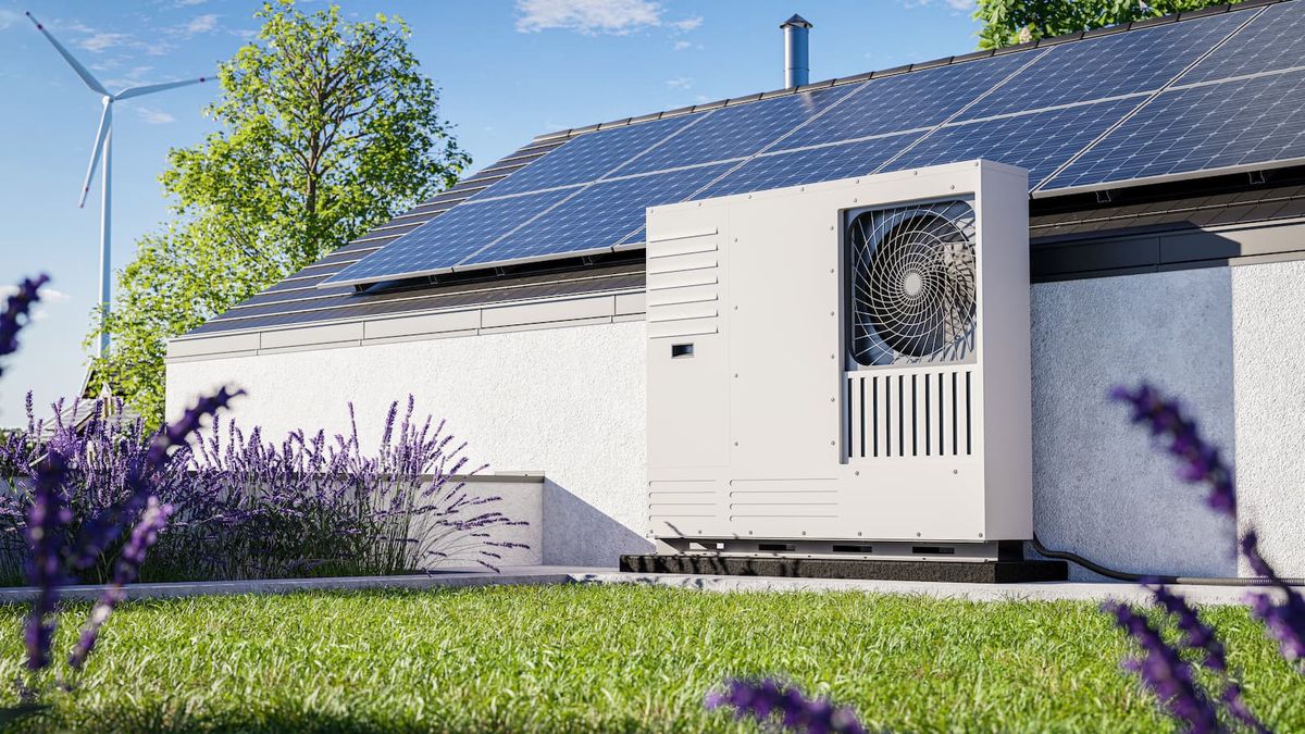 Green roof with grass covering and an installed heat pump with photovoltaic panels on the roof of a single-family house