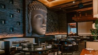 Interior of the Toku Modern Asian restaurant with a huge stone head statue in the middle.