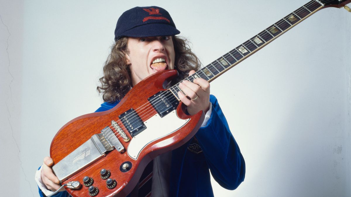 Angus Young of AC/DC, photo shoot dressed in school uniform holding a guitar, Tokyo, Japan, February 1982.