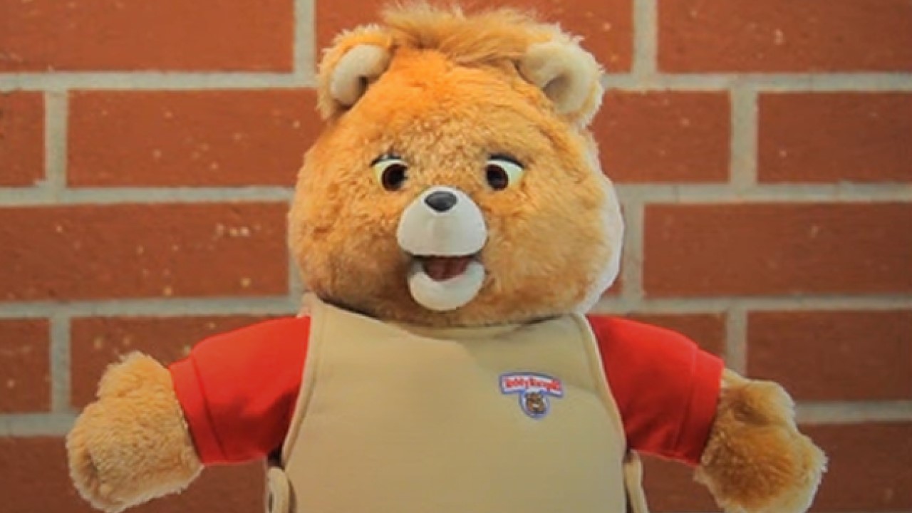 A screenshot of Teddy Ruxpin from a video showing children reacting to '80s toys.
