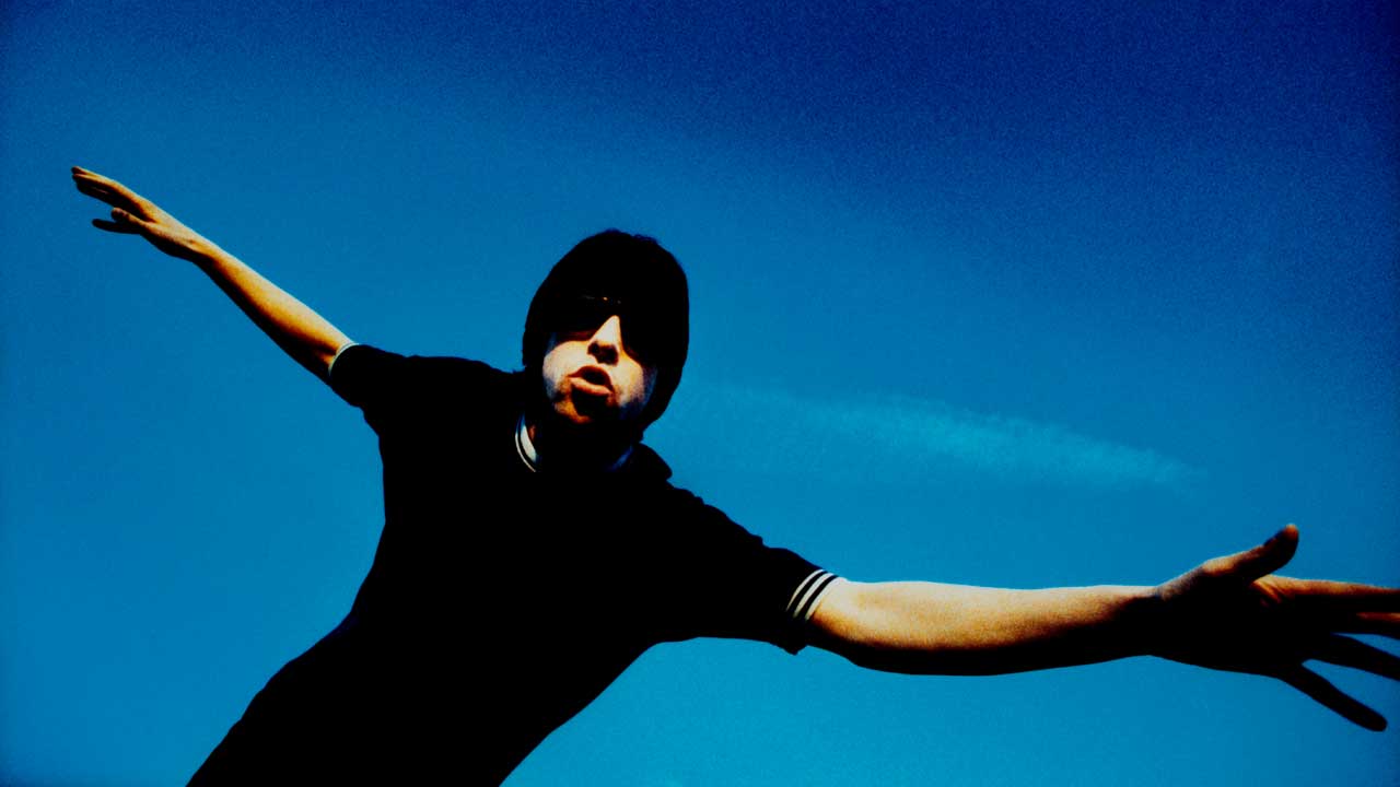 Bobby Gillespie, pictured dancing in front of a bright blue sky