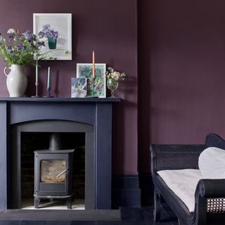 Deep purple living room with traditional black fire surround and wood burner