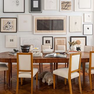 dining room with wall frame and wooden dining table chairs