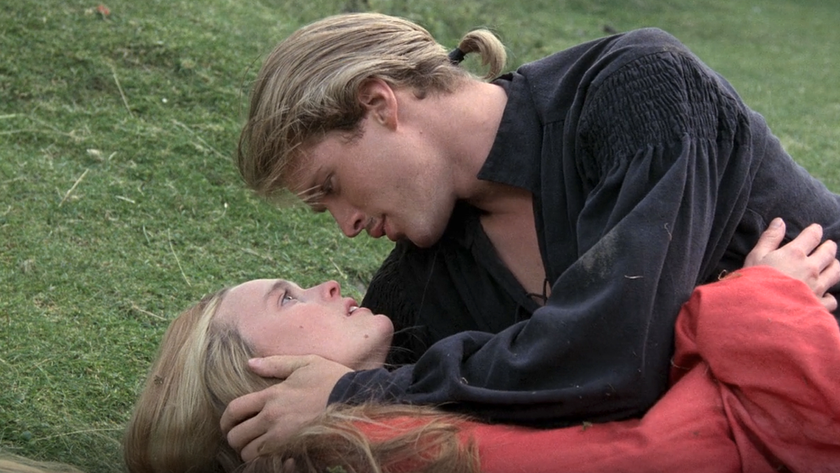 Robin Wright and Cary Elwes laying on the grass while looking at each other in The Princess Bride