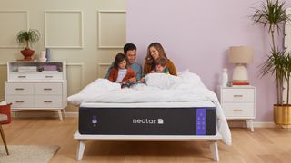 A young family sits together on the Nectar Premier Mattress
