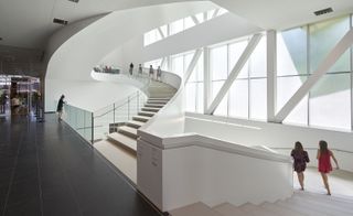 Spacious white interior of building and curved stairs
