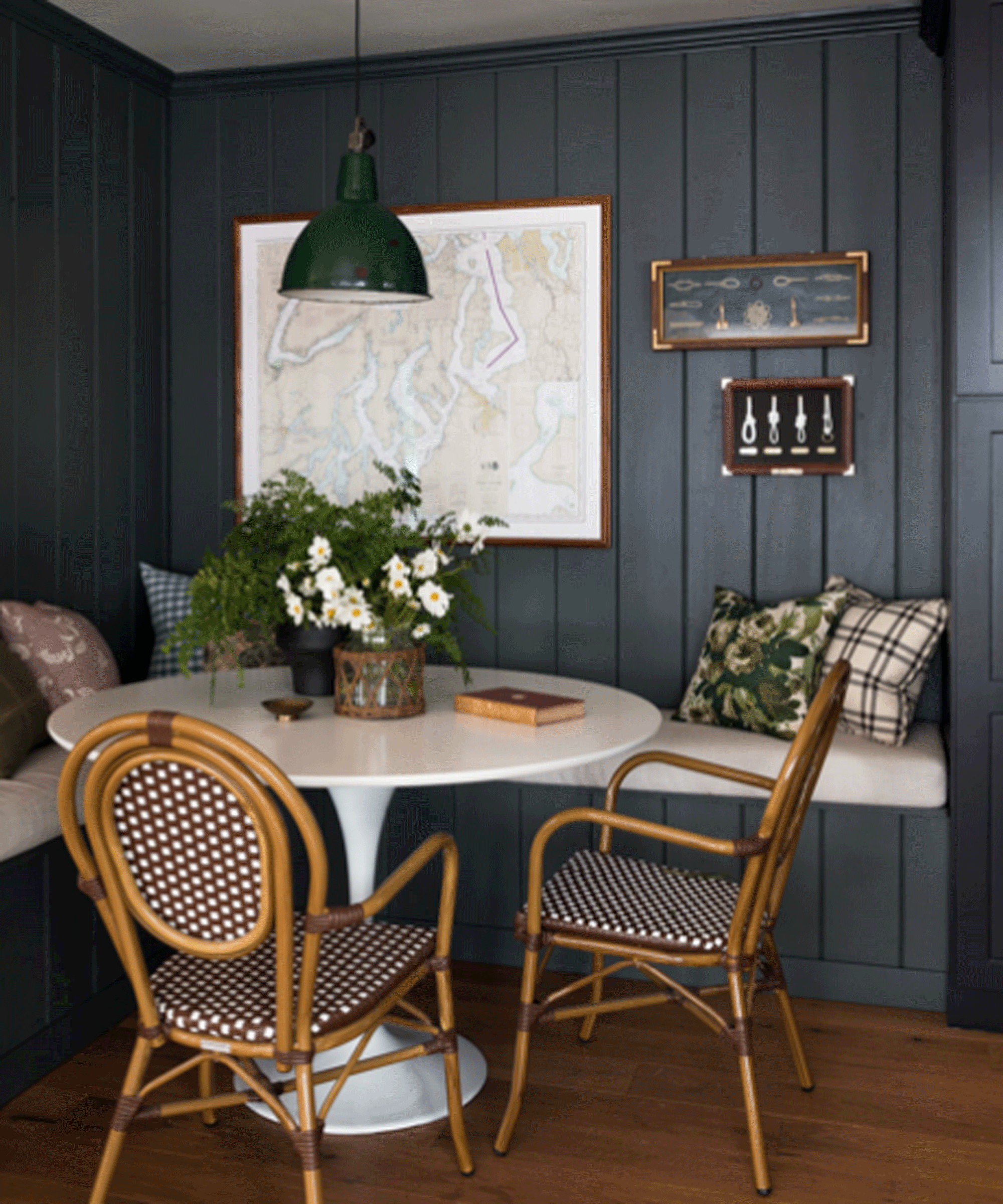 Dining nook with dark walls, round table and cane chairs