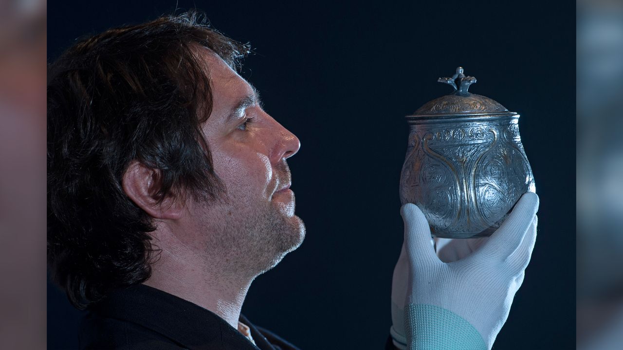 Curator Martin Goldberg holds a reconstruction of the vessel.