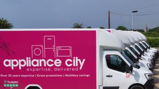 A fleet of Appliance City vans with pink adverts on the side