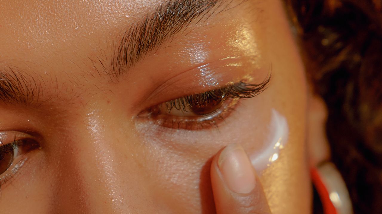 Woman Applying Eye Cream - stock photo to illustrate Glossier serum Futuredew