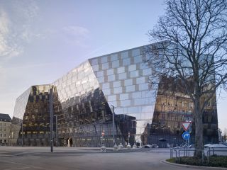 Freiburg City Library by Degelo Architects. A large building with angled glass sides.