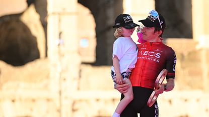 Geraint Thomas holding his son on the podium of the giro d'italia in May 2024