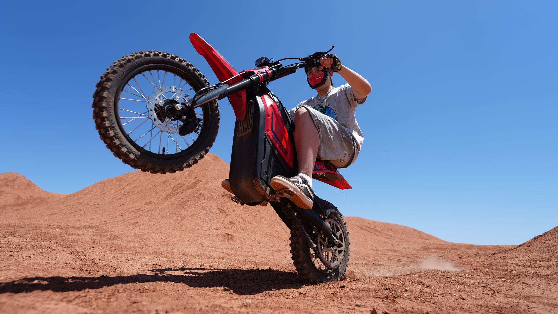 A young person riding the ENGWE Eagle across sand dunes