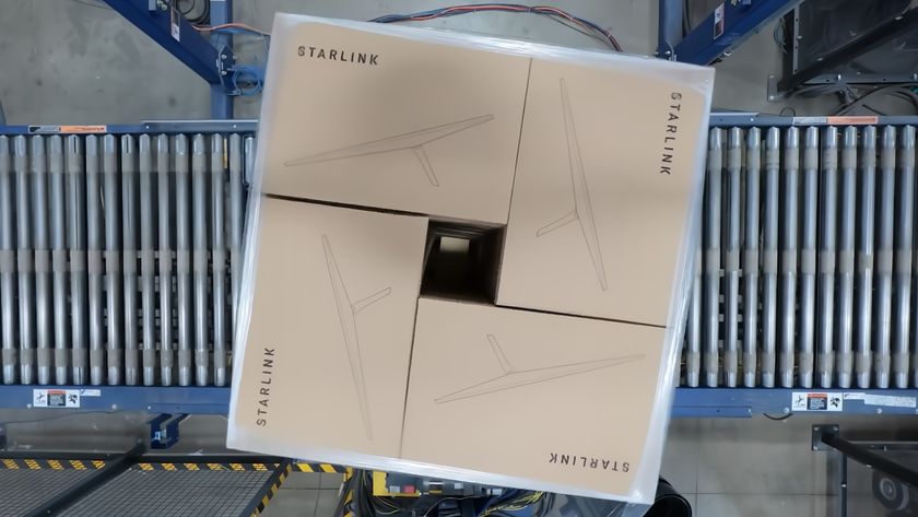 a cardboard box marked with the word &quot;starlink&quot; rolls across a conveyor belt in a factory