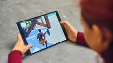 Woman playing fortnite game of epic games company on Apple ios tablet