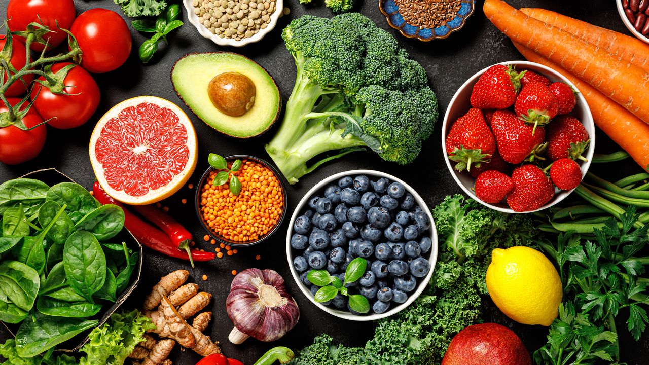 Fruit and vegetable superfoods laid across table