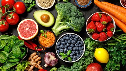 Fruit and vegetable superfoods laid across table