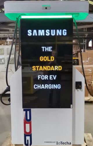 An EV charging kiosk lit up with digital signage from Samsung, IoTecha, and PDG.