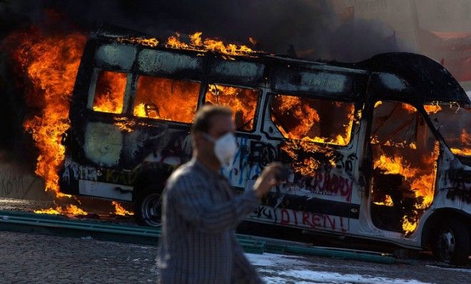 A man walks past a burning car as riot police fire tear gas to disperse the crowd during a demonstration near Istanbul&amp;#039;s Taksim Square on June 11. 