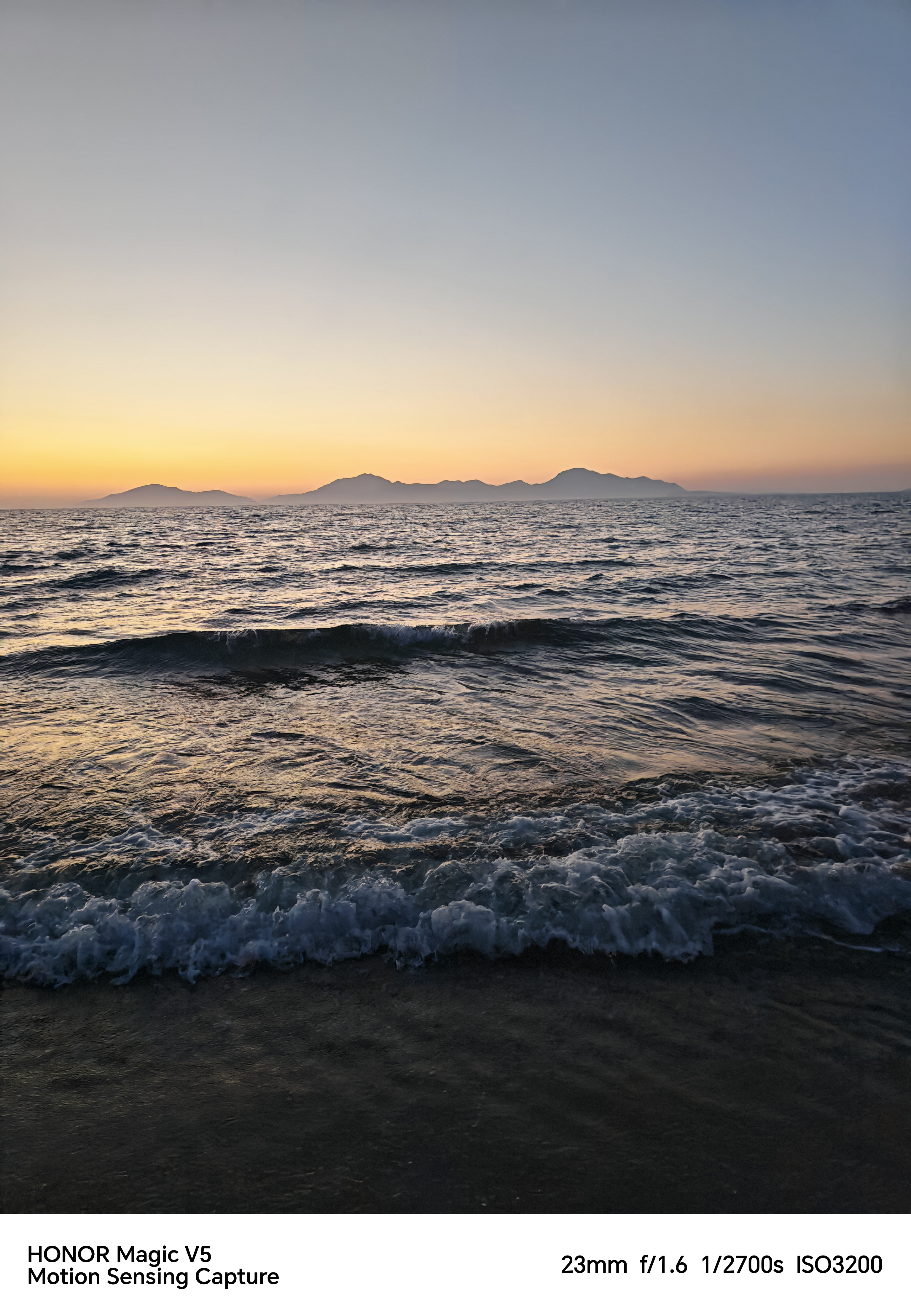 Sunset over the ocean with mountains in the distance