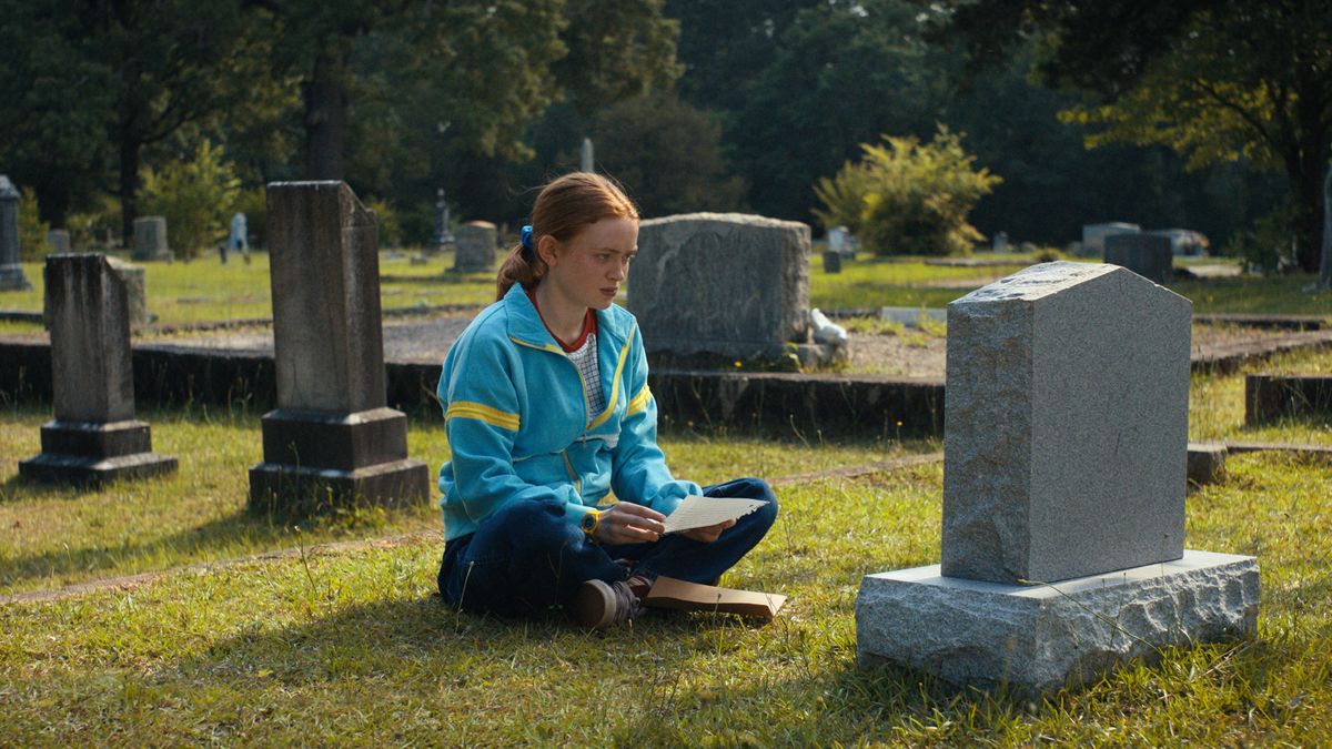 Sadie Sink as Max sitting at a grave in Stranger Things