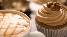 coffee cupcakes topped with a walnut next to a latte 