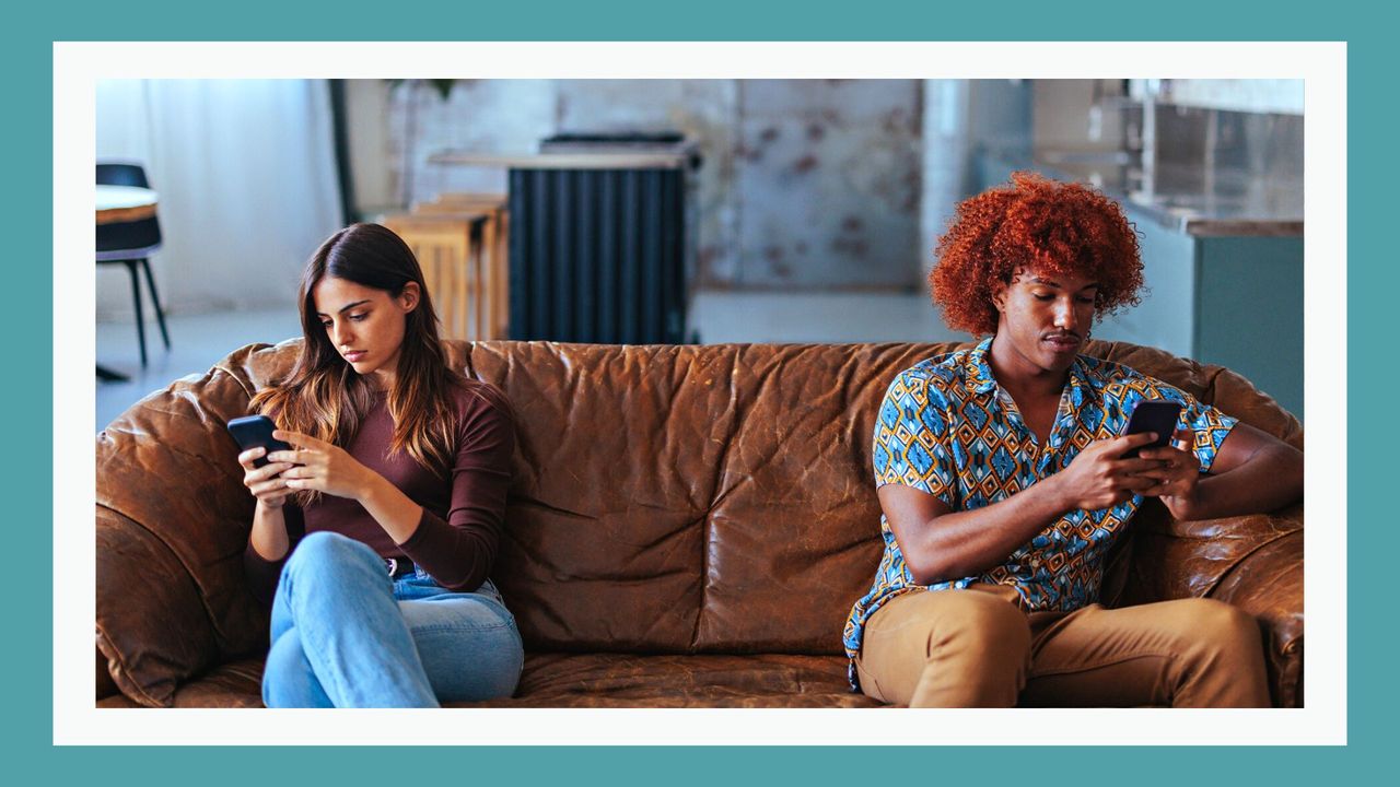 Multiracial young couple sitting separately on the distance while using the mobile phone.