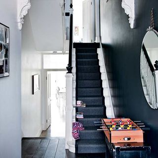 hallway with off black prints and stair runner