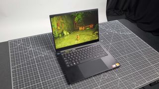 Razer Blade 14 with rgb lit keyboard on a drafting mat in a home office