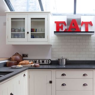 white kitchen with skylights and red decorative letters EAT