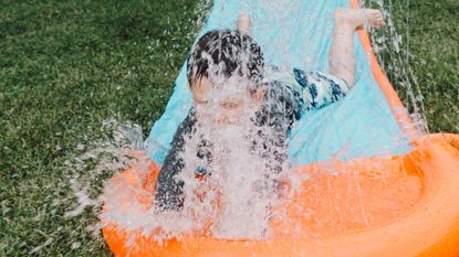 Boy splashing on water mat