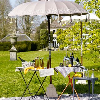 Summer drinks tables on grass under umbrella