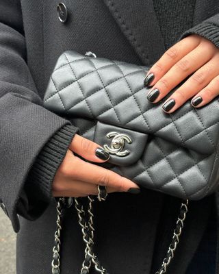 Photo of black nail polish and a Chanel bag