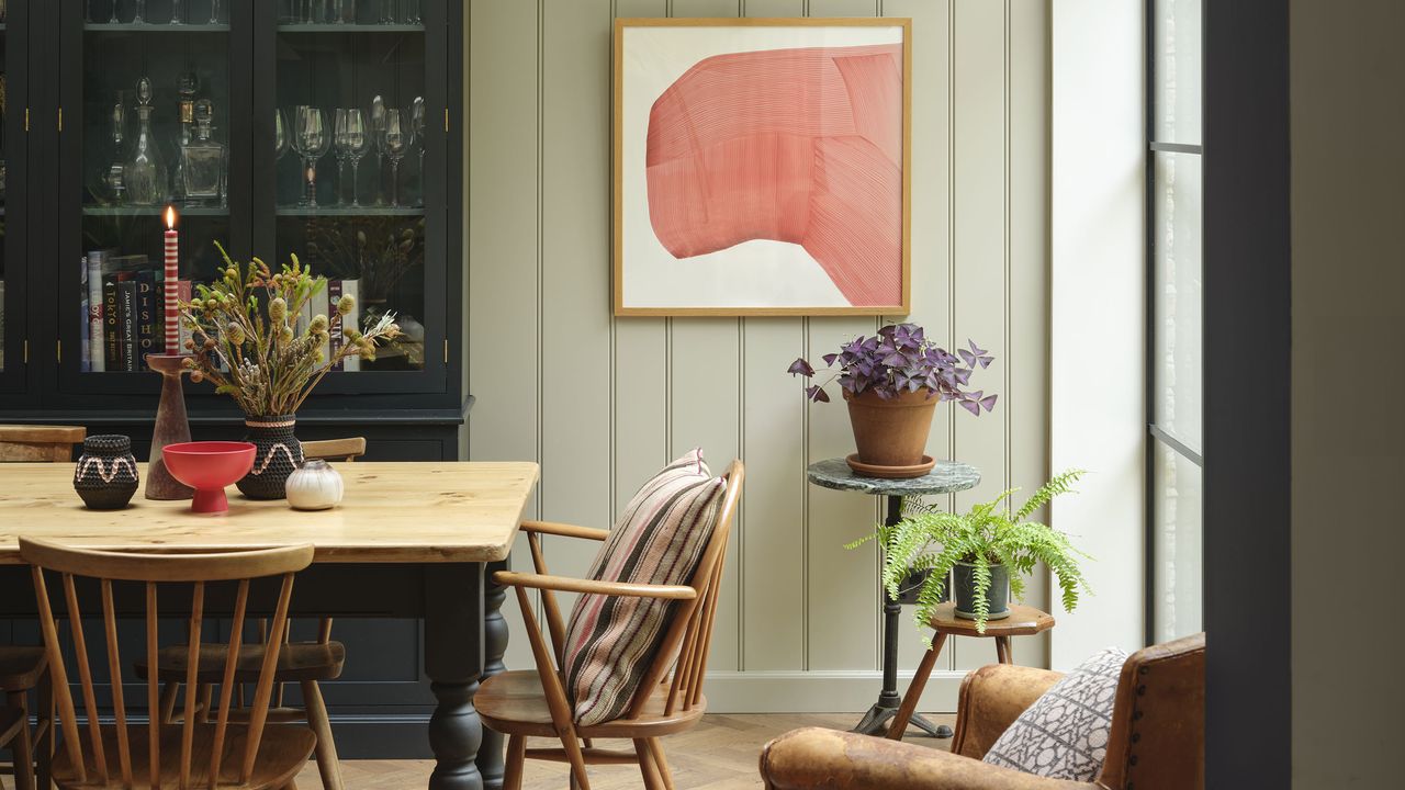 Dining room with wooden table and green painted panelled walls